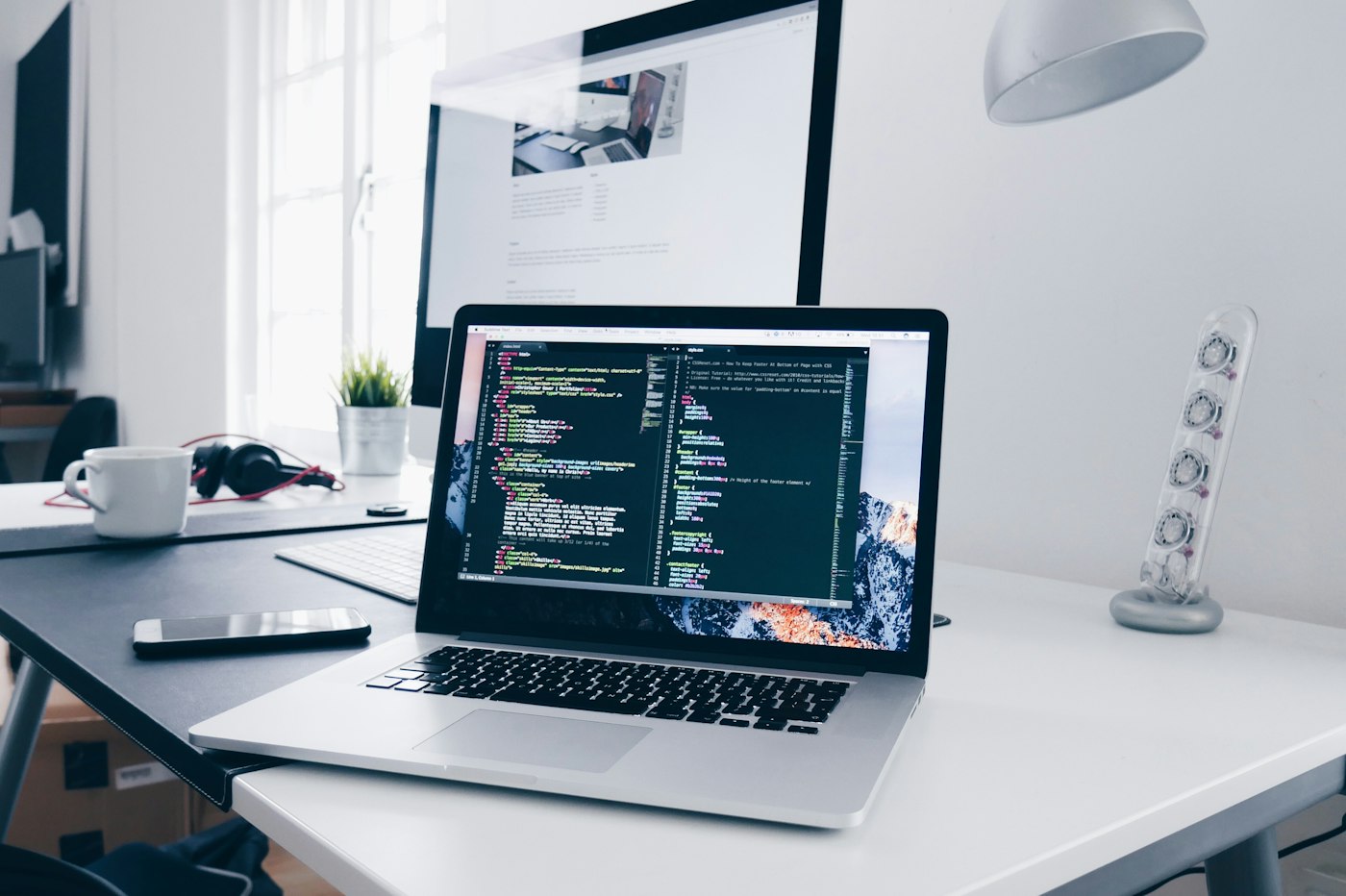 A laptop and notebook on a developer's desk